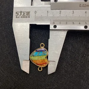 Detalle de colgante de corazón rayado de 15mm con aros dorados para bisutería