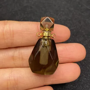 Dettaglio del ciondolo a forma di boccetta di profumo in cristallo con finitura oro