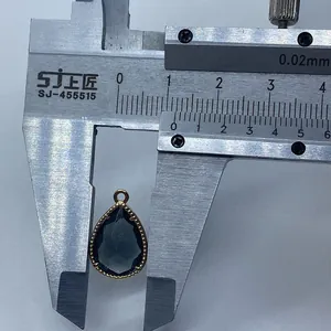 Dettaglio di un ciondolo in pietra sfaccettata misurato con calibro, larghezza circa 13mm