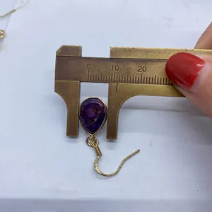 Calipers measuring the 10mm width of purple teardrop semi-precious stone earrings
