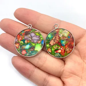Détail de pendentifs ronds en pierre naturelle mosaïque avec bordure en métal argenté