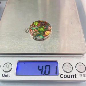 Vue détaillée d'un pendentif ovale en pierre colorée pesant 4,01g sur une balance