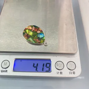 Détail d'un pendentif en pierre naturelle en forme de goutte pesant 4,19g sur une balance