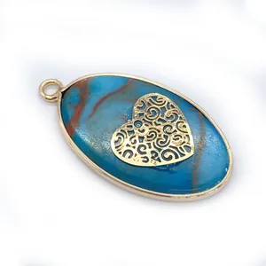 Detailed view of oval blue stone pendant with golden heart filigree and metal frame