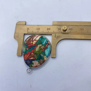 Mesure de la largeur d'un pendentif turquoise avec un pied à coulisse, environ 34mm