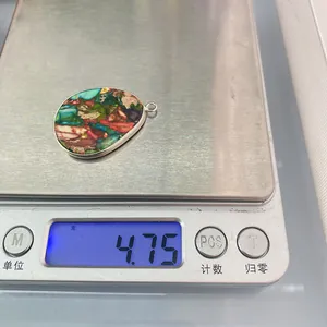 Vue détaillée d'un pendentif en pierre colorée sur une balance pesant 4,75 grammes