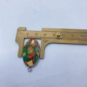 Vue macro d'un pendentif mosaïque turquoise ovale de 18mm avec bordure en métal argent