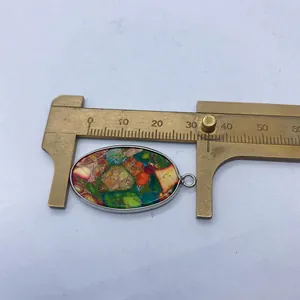 Détail d'un pendentif ovale en turquoise de 35mm avec monture en argent et pied à coulisse