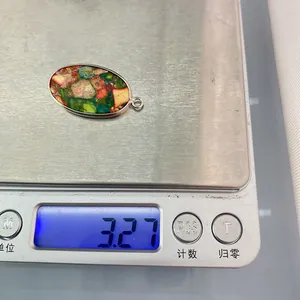 Vue macro d'un pendentif ovale en pierre de 3,27g avec incrustations colorées et métal