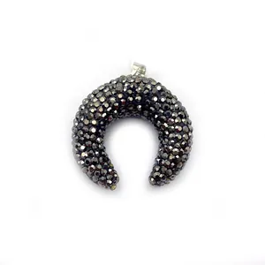 Macro shot of crescent moon pendant with dark grey faceted crystal beads and silver bail