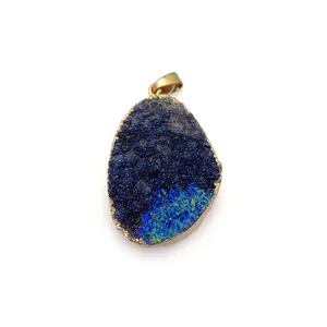 Macro view of blue crystal druzy pendant with gold electroplated metal edge and bail
