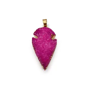 Détail macro du pendentif en quartz druzy rose rouge en forme de feuille aux bords dorés