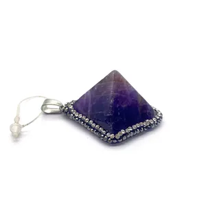Macro shot of pyramid amethyst pendant with sparkling rhinestone details and silver clasp