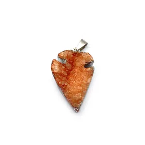 Vue macro détaillée du pendentif pointe de flèche en cristal orange avec bord argenté