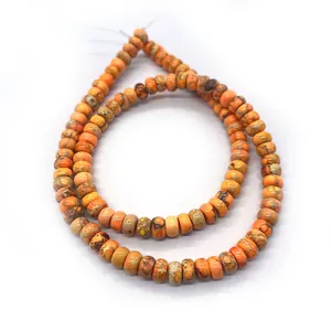 Gros plan de perles en pierre impériale orange avec motifs marbrés naturels pour bijoux DIY