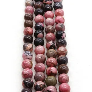Vue détaillée de perles rondes en rhodonite naturelle polie aux motifs rose et noir