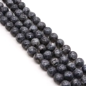 Macro detail of polished dark grey natural stone beads with unique speckled rock textures