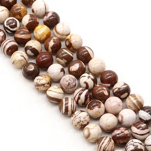 Vue macro de perles rondes en pierre zébrée naturelle avec rayures marron et beige pour bijoux