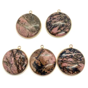 Macro view of five round rhodonite stone pendants with gold plated edges for DIY jewelry