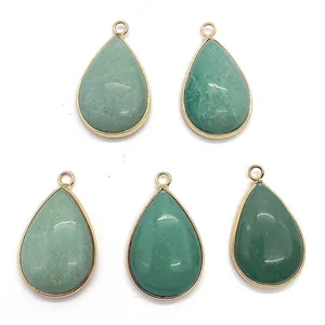 Detailed macro view of five water drop green stones with gold plated frames and top loops