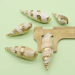 Macro view of white natural shell pendants with gold trim and top metal ring for DIY