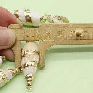 Macro view measuring natural shell pendant size with caliper for DIY jewelry making