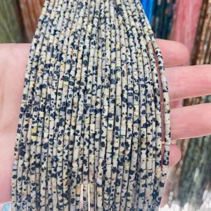 Gros plan de perles cylindriques en jaspe dalmatien naturel pour bijoux DIY