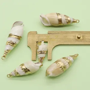 Detail view of gold-plated white sea snail shell pendant measured with a caliper