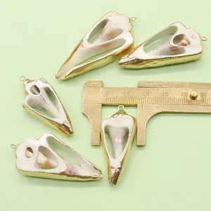 Detailed view of natural shell pendants with gold plated edges and measurement caliper