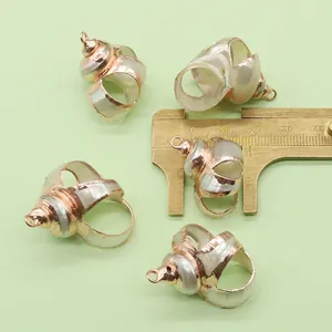 Macro shot of rose gold plated natural shell pendants with measuring brass caliper