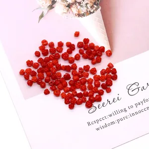 Detail van rode roosvormige synthetische koraalkralen voor het maken van DIY-sieraden