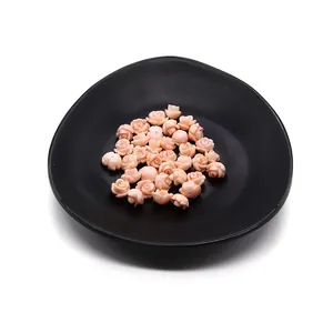 Detailed view of pink rose-shaped coral beads in a black dish for jewelry DIY making