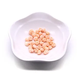 Top view of pink synthetic coral rose beads for DIY jewelry making in a white ceramic bowl