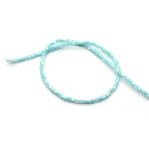 Vue détaillée de perles cylindriques bleu clair en nacre avec un éclat naturel pour DIY