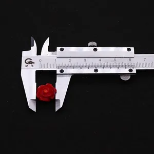 Makroaufnahme einer roten Korallenrosenperle mit 11 mm Durchmesser am Messschieber