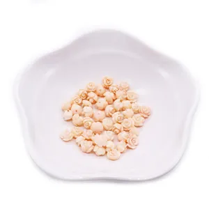 Pink synthetic coral rose flower beads for DIY jewelry making in a white petal dish