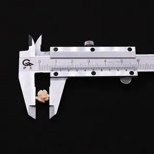 Macro view of a 10mm white carved rose bead being measured by a metal caliper