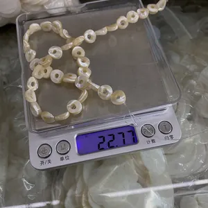 Makroaufnahme von Naturmuschel-Donut-Perlen auf einer Digitalwaage mit 22,77g