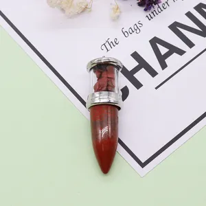 Bullet-shaped natural stone pendant with silver frame and red crystal inlay detail