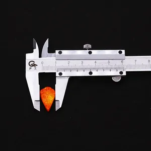 Macro detail of orange carved leaf bead showing 1.1cm width with a digital caliper