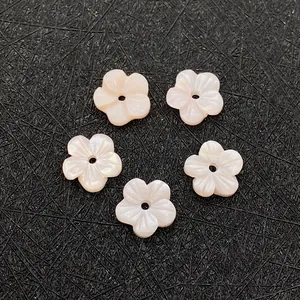 Macro-opname van vijf roze schelpkralen in bloemvorm voor DIY-sieraden