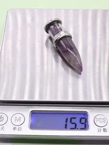 Detailed view of a purple crystal bullet pendant weighing 15.9g on a digital scale
