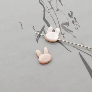 Macro shot of a bunny shaped pink shell bead with pearl luster and threading hole
