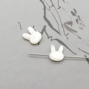 Macro detail of rabbit-shaped natural shell beads with drill holes for DIY jewelry