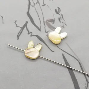 Detailed view of rabbit-shaped natural shell beads with drill holes for DIY jewelry