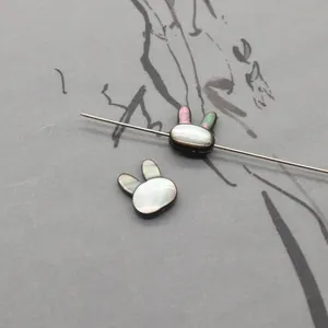 Detailed view of rabbit-shaped black shell beads with natural iridescence for DIY jewelry
