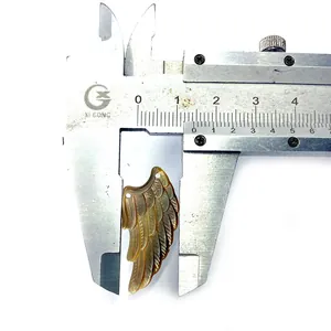 Makroaufnahme zeigt Maße des 12mm geschnitzten Muschelflügels mit einem Messschieber