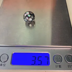 Detailed macro shot of a mosaic shell pearl pendant weighing 3.57g on a digital scale