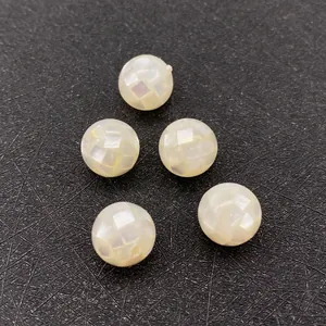 Detailed view of mosaic-patterned white sea shell round beads for DIY jewelry