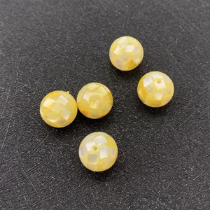 Macro shot of 5 yellow shell beads with mosaic pattern for DIY necklace making